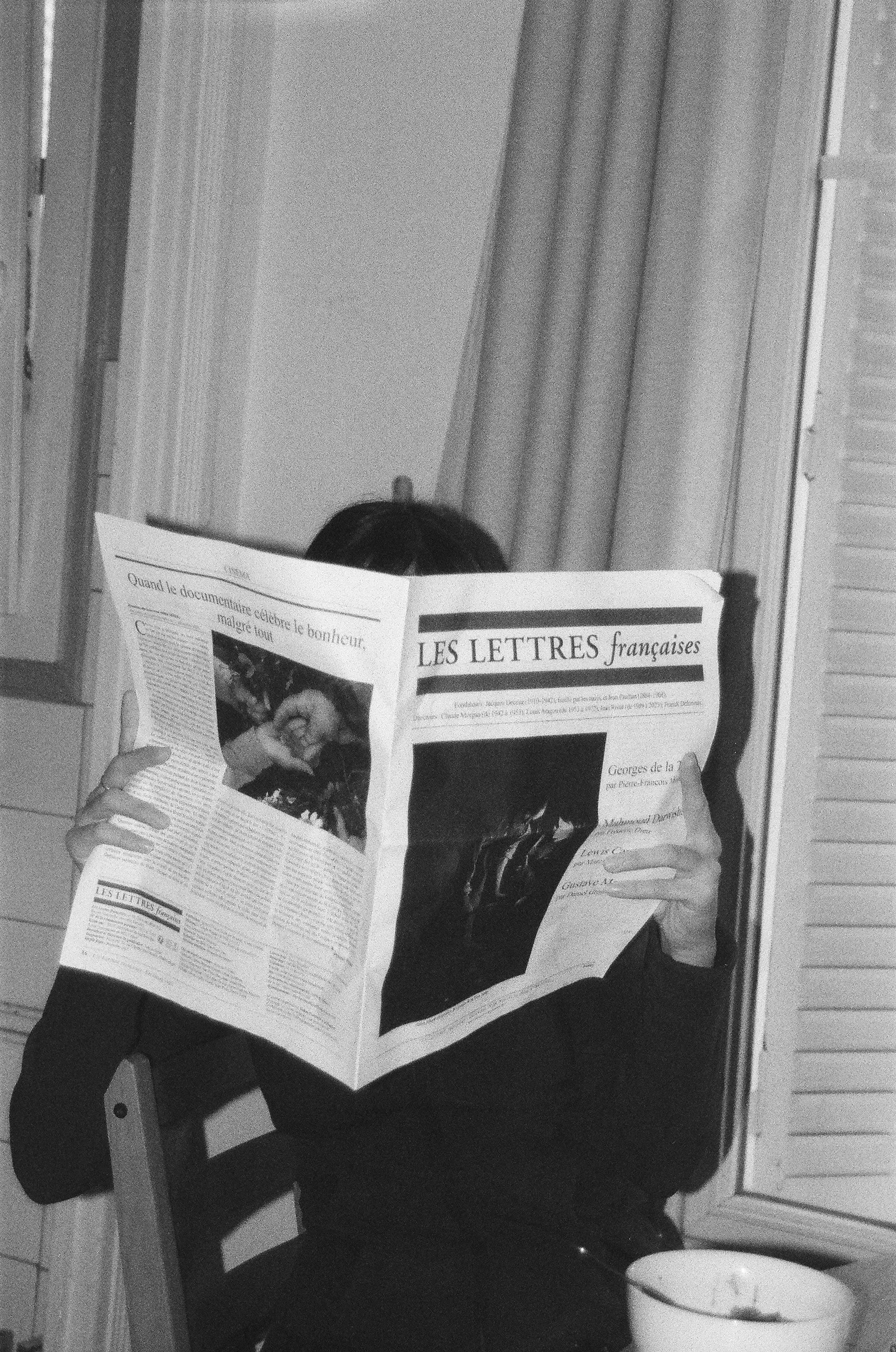 personne lisant son journal, photo en noir et blanc